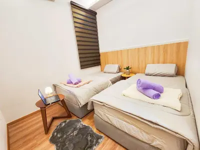 a room with two beds with purple pillows on them at The Cove Ipoh Garden East, Taman Ipoh Permai, Garden East, 31400 IPOH in Ipoh