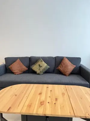 a blue couch with pillows and a wooden table at Beacon Executive Suites #CozyFamilyStay #RoofTopPool #13 in George Town