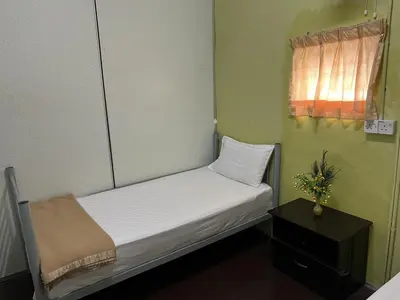 a small bed in a small room with a window at De Cameron Guest House in Tanah Rata