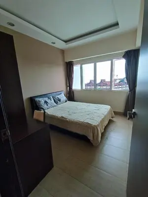 a bedroom with a bed and a large window at Lovers Island homestay in Batu Ferringhi