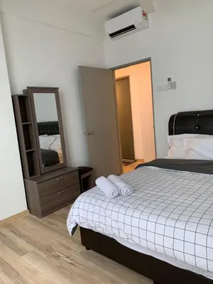 a bedroom with a bed with two pillows and a mirror at Barakah Homestay @ Meru Casa Kayangan in Ipoh