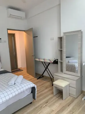 a bedroom with a bed and a desk and a mirror at Barakah Homestay @ Meru Casa Kayangan in Ipoh