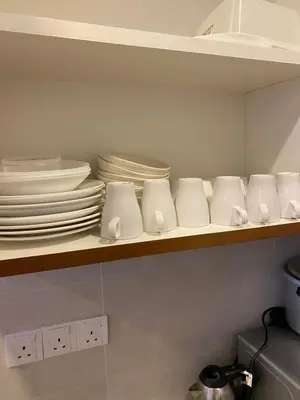 a kitchen shelf with plates and dishes on it at zarraz homestay The Retreat Nova Kea Farm Brinchang in Brinchang