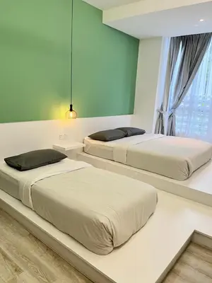 two beds sitting in a bedroom with a window at Emerald Avenue Cozy 3R3B Apartment - 329 in Brinchang
