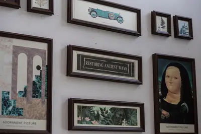 a wall with framed pictures on a wall at De Luma-Metropol in Bukit Mertajam