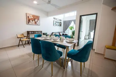 a dining room with a table and blue chairs at De Luma-Metropol in Bukit Mertajam