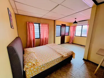 a bedroom with a bed in a room with windows at Halim's Rumah Singgah Mxslim only in Jelutong