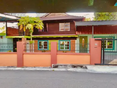 a house with an orange door and a fence at Halim's Rumah Singgah Mxslim only in Jelutong