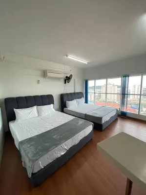 a bedroom with two beds and a table and windows at 4PAX near USM n Pantai Hospital n PISA SPI CE ARENA in Bayan Lepas