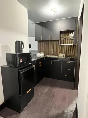 a kitchen with black cabinets and a black stove at SAMSARA Studio Apartment at Kompleks Mutiara GM in Gua Musang
