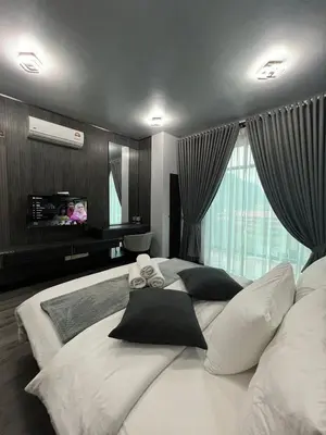 a bedroom with a large white bed with pillows at SAMSARA Studio Apartment at Kompleks Mutiara GM in Gua Musang