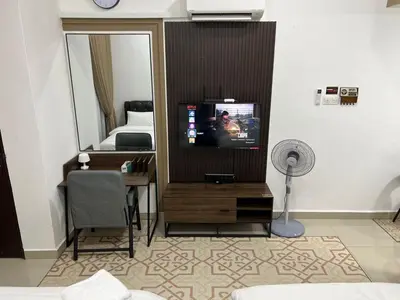 a room with a tv and a bed and a mirror at HASSMA Studio Apartment at Kompleks Mutiara GM in Gua Musang