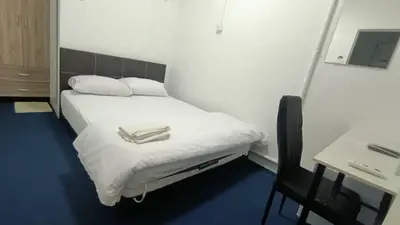 a bedroom with a bed and a desk and a chair at 246housecafe in George Town