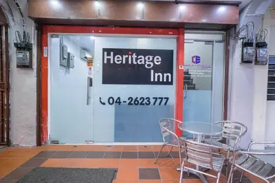 a store front door with a table and chairs outside at Heritage Inn in George Town
