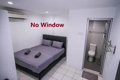 a room with a bed with a no window sign on it at Heritage Inn in George Town