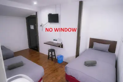 a room with two beds and a no window sign at Heritage Inn in George Town