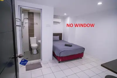 a bathroom with a bed and a shower and a no window sign at Heritage Inn in George Town