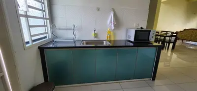 a kitchen with a sink and a microwave at Bertam Homestay Kepala Batas in Kepala Batas