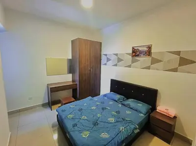 a bedroom with a bed with a blue comforter at Freezing Point Homestay @ Palas Horizon Residence in Cameron Highlands