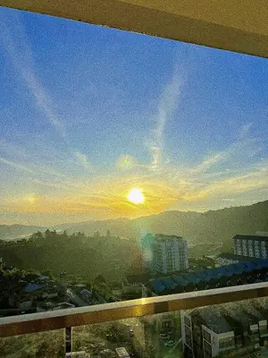 a view of the sunset from a window of a building at Freezing Point Homestay @ Palas Horizon Residence in Cameron Highlands