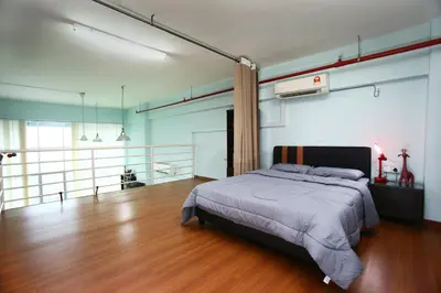 a bedroom with a bed and a wooden floor at Private Rock Climb at The CEO Penang in Bayan Lepas