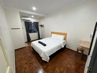 a bedroom with a bed with a white comforter at Homestay Suria in Kuala Kangsar