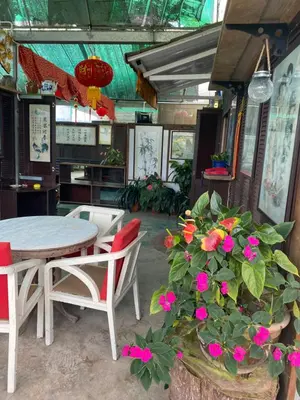 a dining room with a table and chairs and flowers at New Farmer Hut 2 in Brinchang