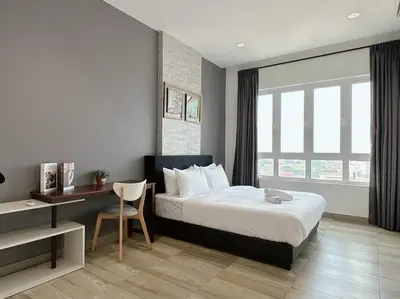 a hotel room with a bed and a desk and a desk at Ipoh Town - Octagon Cozy Deluxe Homestay in Ipoh