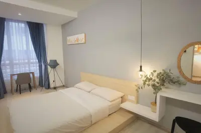 a white bedroom with a bed and a fireplace at Emerald Avenue Cozy 1BR Studio Suite in Brinchang