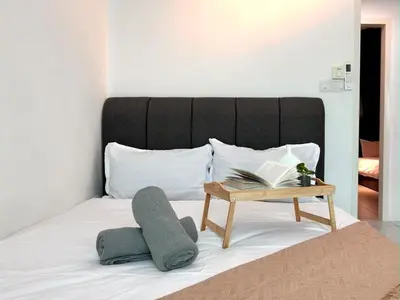 a bed with a table with a book on it at JOVIAL Modern Cozy Homestay `Meritus Perai in Perai