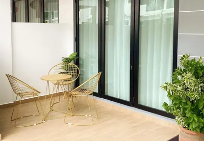 a table and chairs on a balcony with windows at Pangkor Villa88 Double Storey 3min to Pasir Bogak Beach in Pangkor