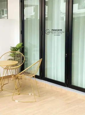 a table and chairs in front of a window at Pangkor Villa88 Double Storey 3min to Pasir Bogak Beach in Pangkor