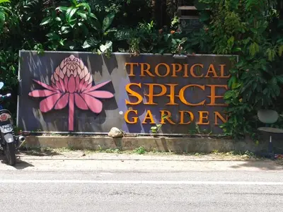 a sign for a tropical spice garden on the side of the road at Have a pleasant stay with Bayu Emas Homestay in Batu Ferringhi