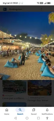 a group of people sitting on blue lounge chairs on the beach at Have a pleasant stay with Bayu Emas Homestay in Batu Ferringhi