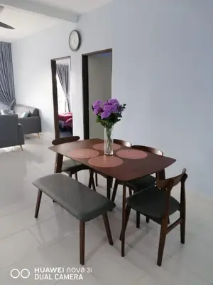a dining room table with a vase of flowers on it at Alyaleesya homestay Emerald Avenue 1 Brinchang in Brinchang