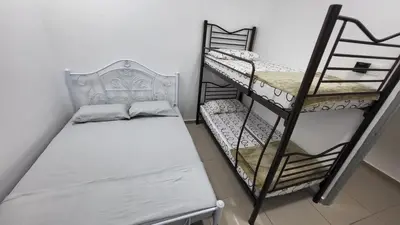 a small room with two bunk beds and a bench at Sri MaLati Homestay and Event Space in Balik Pulau