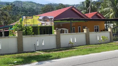 a house on the side of the road with a fence at Sri MaLati Homestay and Event Space in Balik Pulau