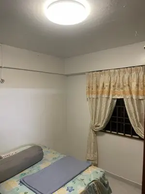 a bedroom with a bed and a window at Family House in Jelutong