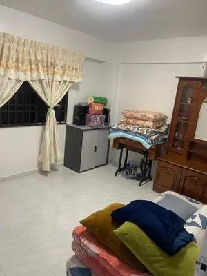 a living room with a bed and a table at Family House in Jelutong