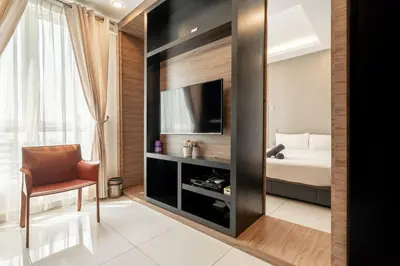 a bedroom with a bed and a television in a room at Mansion One Executive Studio 2pax in George Town