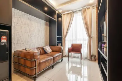 a living room with a brown leather couch and a chair at Mansion One Executive Studio 2pax in George Town