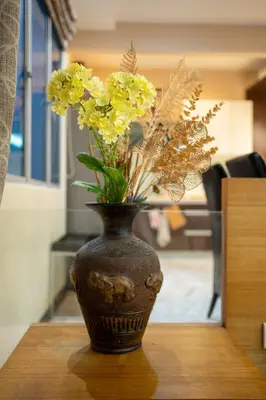 a vase with yellow flowers in it on a table at Cozy Gurney Georgetown Private Apartment Penang in George Town