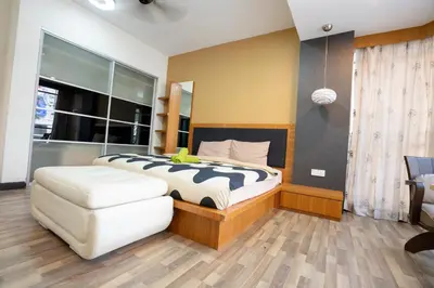 a bedroom with a large bed and a white chair at Cozy Gurney Georgetown Private Apartment Penang in George Town