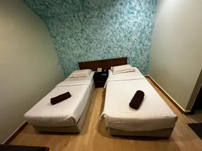 two beds in a small room at GOA INN HOTEL SDN BHD in Gua Musang
