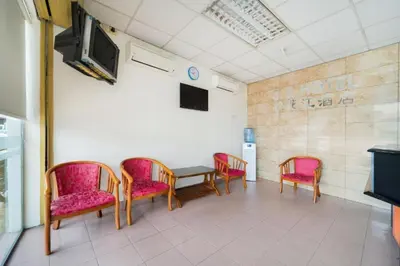 a waiting room with chairs and a table and a tv at CP Hotel in Butterworth