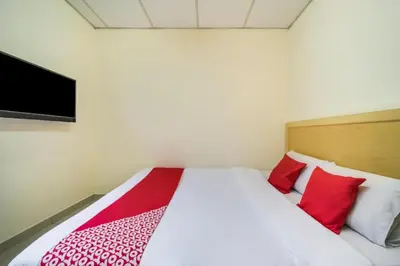 a bedroom with a bed with red pillows and a tv at Hotel River Inn in Butterworth
