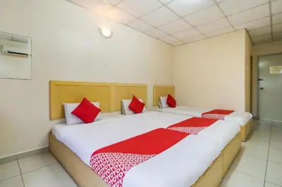 a bedroom with two beds with red and white pillows at Hotel River Inn in Butterworth
