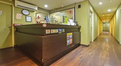 a long hallway with a cash counter and a clock at Juru Hotel in Bukit Mertajam