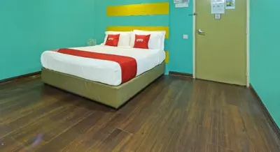 a bedroom with a bed with red pillows on it at Juru Hotel in Bukit Mertajam