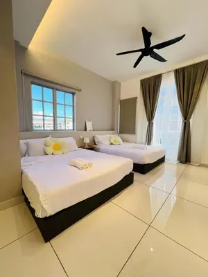 a bedroom with two beds and a ceiling fan at Inn Homestay in Teluk Intan